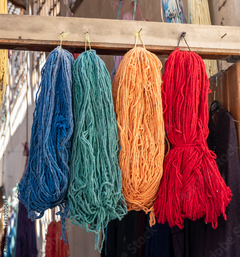 Skeins of colorful yarn hanging in the alleyways in the ancient medina souk in Fes Morocco photo