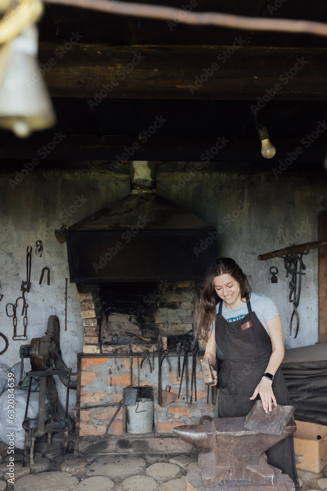 Young woman blacksmith portrait in workshop