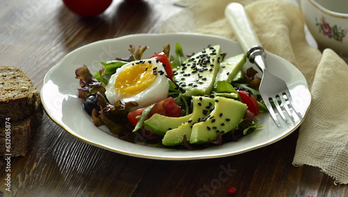 Avocado salad with olives, tomatoes, lettuce, arugula and boiled egg