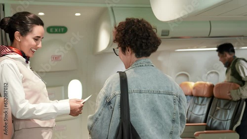 Beautiful and attractive asian flight attendant staff smiling. Passenger giving passport with boarding pass to air hostess woman check on airplane. Cabin crew or stewardess occupation concept.