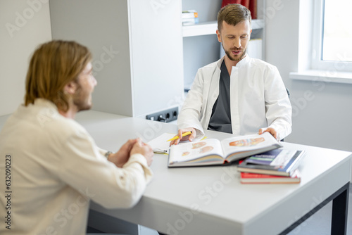Confident vascular surgeon during a consultation with a male patient in medical office. Concept of vascular surgery for the treatment of varicose veins. Real doctor portrait