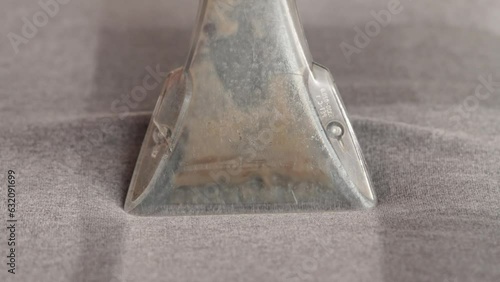 Cleaning concept. Woman washes soft furniture in living room. Employee removing dirt from furniture, closeup