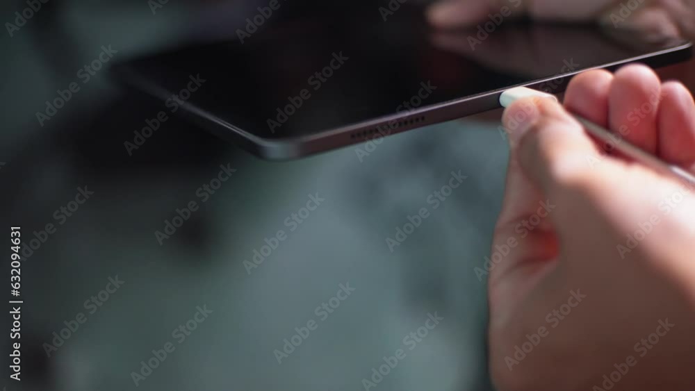 Charging Tablet using the power from connecting cable from adapter, close-up shot Charging Tablet using the power from connecting cable from adapter, close-up shot