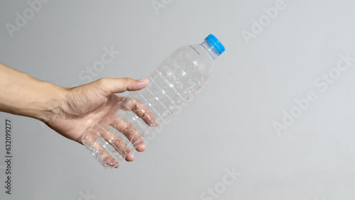 hand holding water bottle.plastic water bottle. Stop using plastic water bottles. Love the world, stop using plastic.