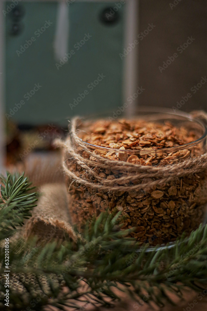 Cozy christmas food on the table in a glass bowl of granola oatmeal with rose nuts and dried fruits