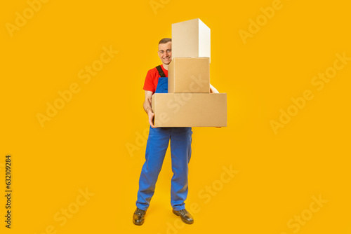 Loader or courier with parcels. Young man in uniform with several large boxes. Copy space, mock up. photo