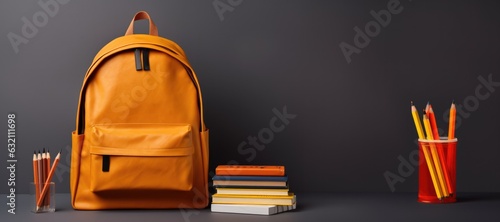 Orange school backpack from which sticks out, a ruler, a pen, pencils and notebooks, on a plain background. Back to school concept for new knowledge and education, college and university education