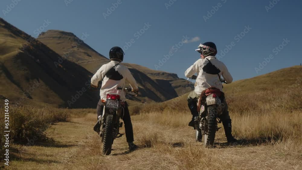 Two mountain motorcyclists start aggressively on a rocky mountain road. Mountain bikes in the mountains ride on a mountain road. Travelers and adventurers. Extreme motorcycle riding. Vintage Two mountain motorcyclists start aggressively on a rocky mountain road. Mountain bikes in the mountains ride on a mountain road. Travelers and adventurers. Extreme motorcycle riding. Vintage