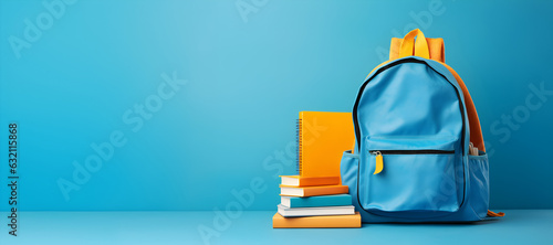 un sac à dos et des livres sur fond bleu ciel pour illustrer le concept de rentrée scolaire photo