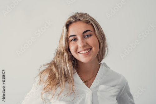 Close up overjoyed woman laughing, sitting on couch at home, head shot portrait young female chatting online with friends or relatives, looking at camera, having fun, making call or shooting video.