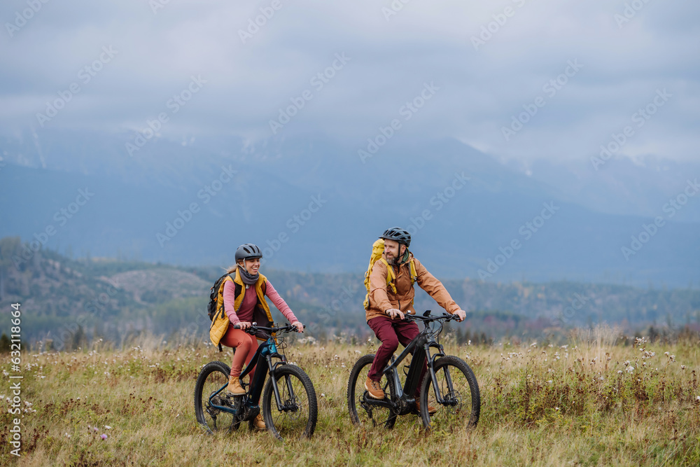 Happy couple at bicycles, in the middle of autumn nature. Concept of a healthy lifestyle.