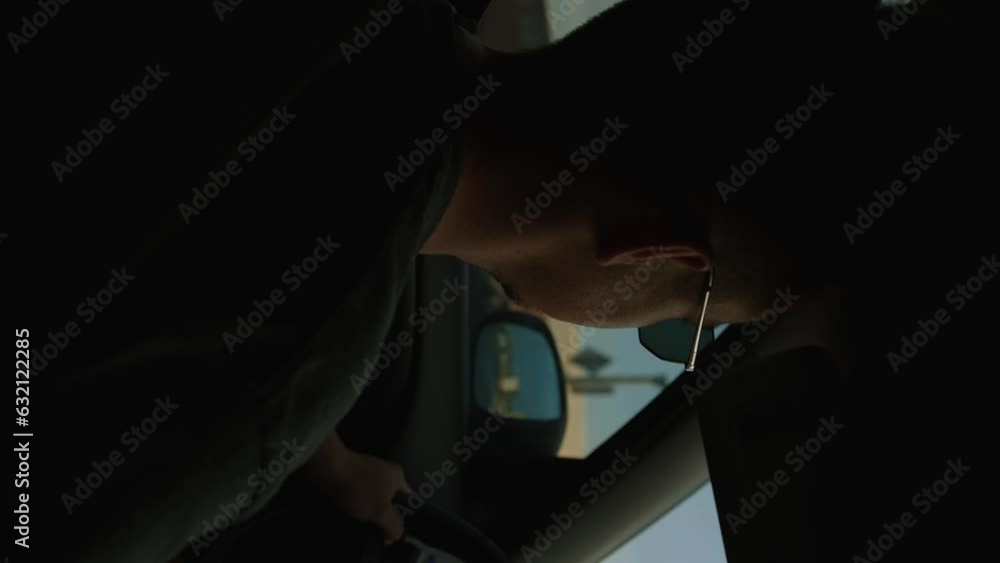 Young man in sunglasses travels behind wheel of his car. Inside view Young man in sunglasses travels behind wheel of his car. Inside view