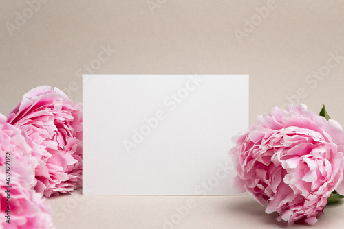Fototapeta Naklejka Na Ścianę i Meble -  Blank wedding invitation card mockup with pink fresh peony flowers, white card mock up with copy space