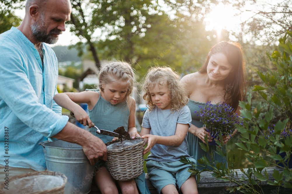 Fototapeta premium Happy family taking care of plants in the garden.