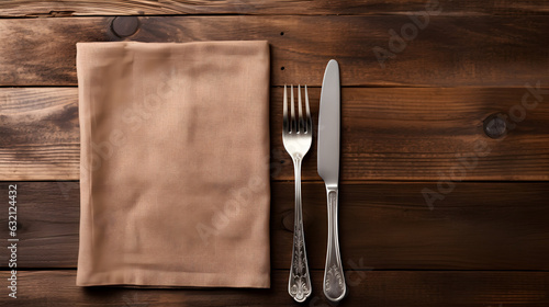vu de dessus, une serviette en lin, une fourchette et un couteau sur une table en bois