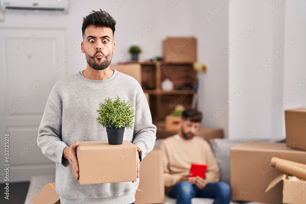 Homosexual couple moving to a new home making fish face with mouth and squinting eyes, crazy and comical. Homosexual couple moving to a new home making fish face with mouth and squinting eyes, crazy and comical.