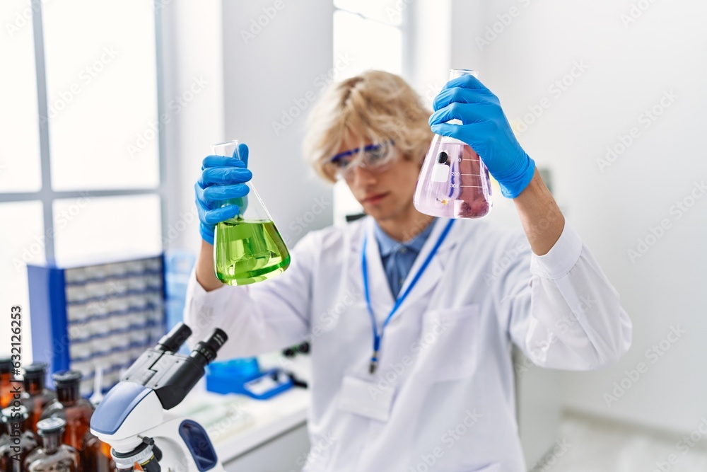 Young blond man scientist holding test tubes at laboratory Young blond man scientist holding test tubes at laboratory