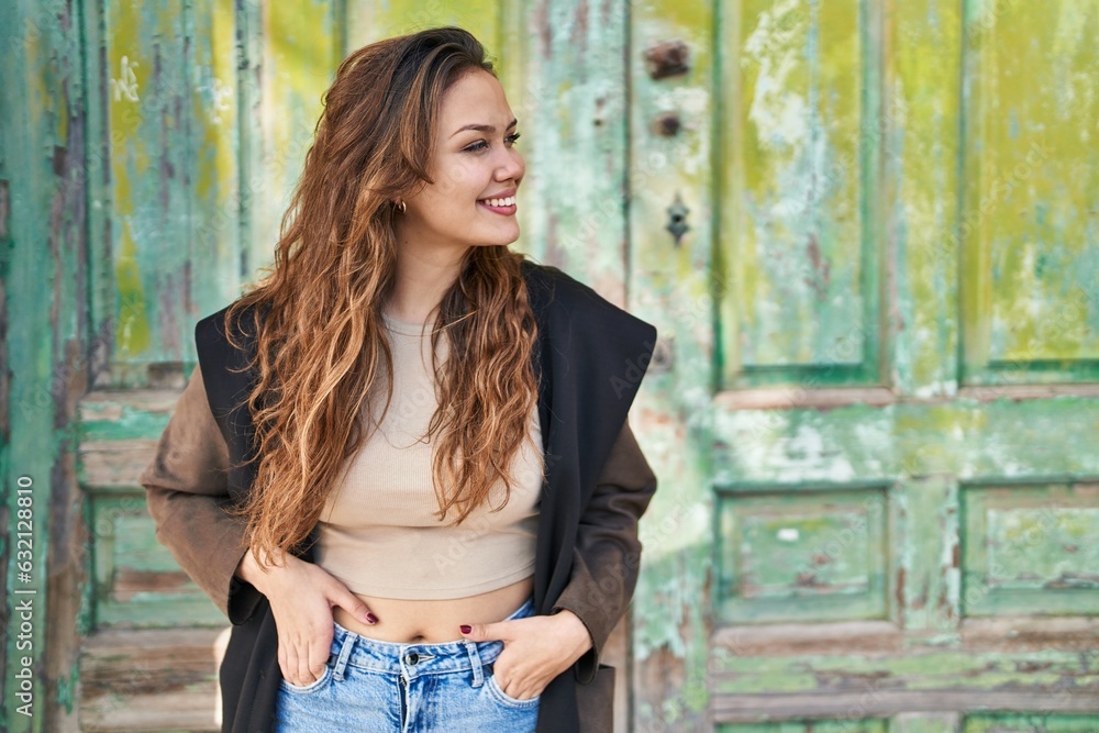 Fototapeta premium Young beautiful hispanic woman smiling confident looking to the side at street
