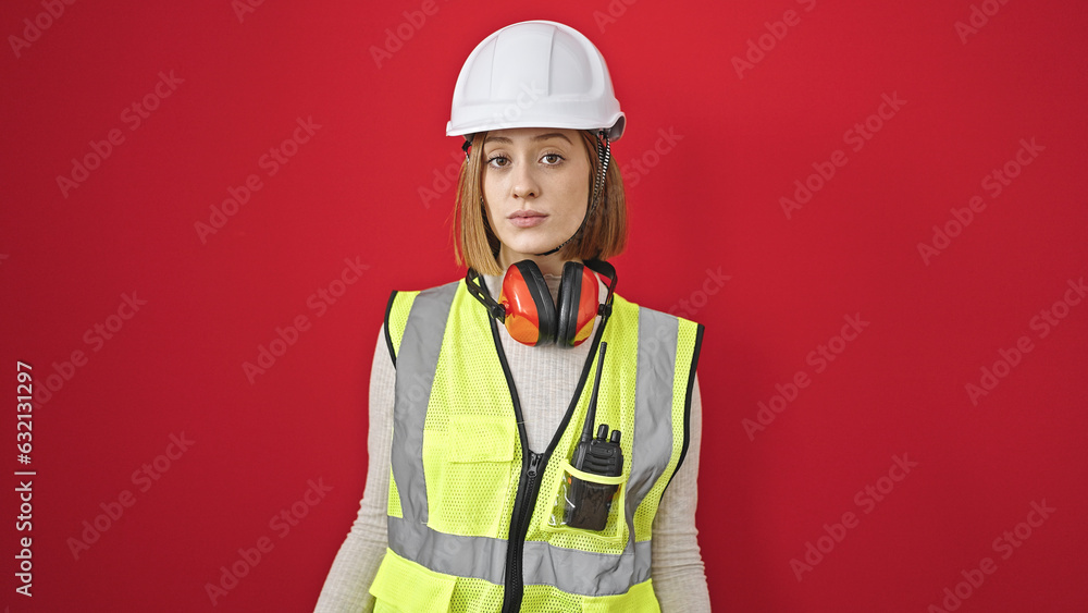 Young blonde woman architect standing with relaxed expression over isolated red background Young blonde woman architect standing with relaxed expression over isolated red background