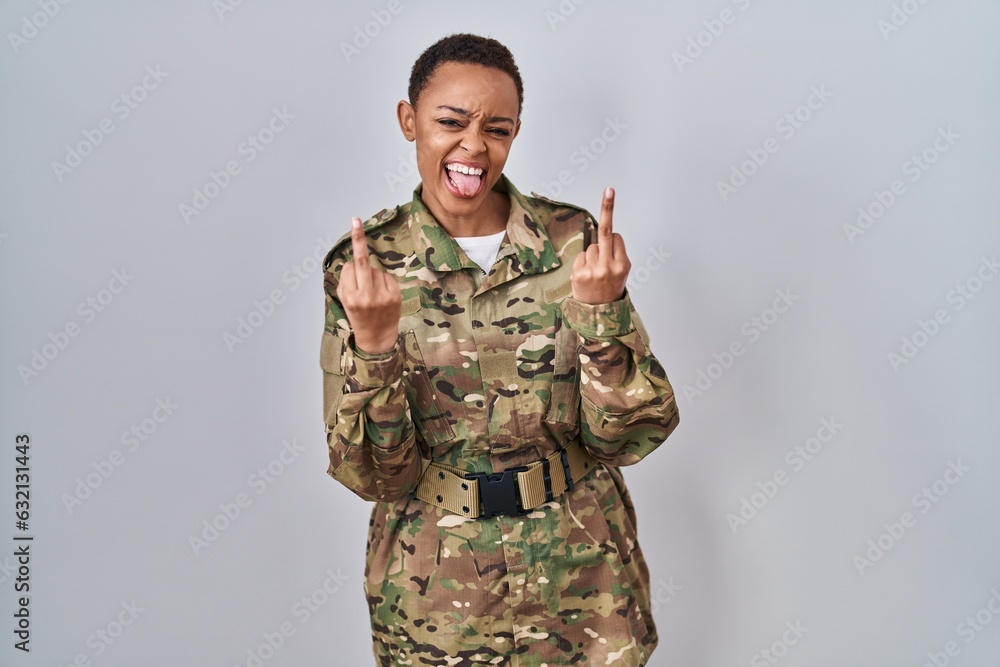 Beautiful african american woman wearing camouflage army uniform showing middle finger doing fuck you bad expression, provocation and rude attitude. screaming excited Beautiful african american woman wearing camouflage army uniform showing middle finger doing fuck you bad expression, provocation and rude attitude. screaming excited