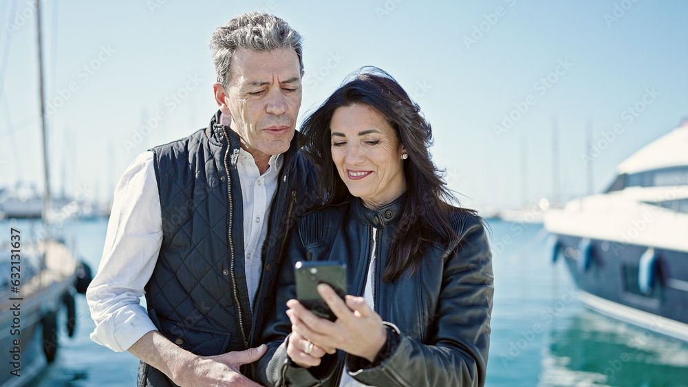 Senior man and woman couple smiling confident using smartphone at port Senior man and woman couple smiling confident using smartphone at port