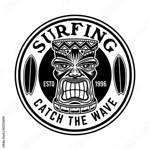 Surfing vector emblem, badge, label, sticker or logo with tiki head and surfboards. Illustration in vintage monochrome style isolated on white background