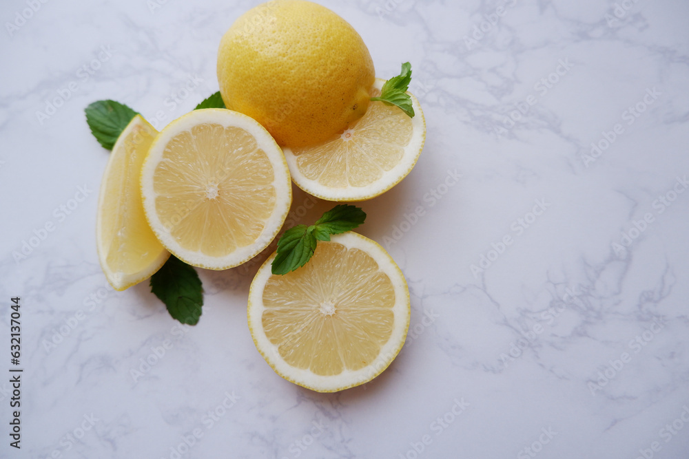 Fresh lemons composition on white marble background. Freshness and vitamin healthy fruits background. Slice lemons and fresh mint. Fresh lemons composition on white marble background. Freshness and vitamin healthy fruits background. Slice lemons and fresh mint.