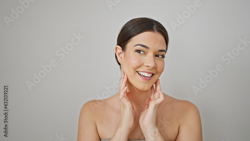 Young beautiful hispanic woman smiling confident massaging face over isolated white background