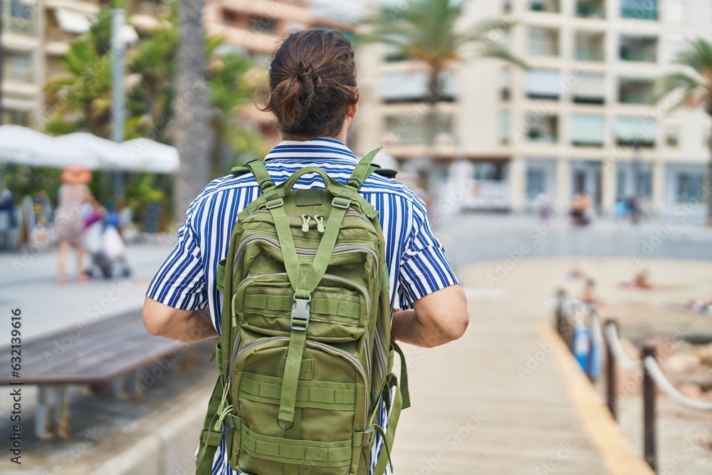 Young hispanic man tourist wearing backpack walking at street Young hispanic man tourist wearing backpack walking at street