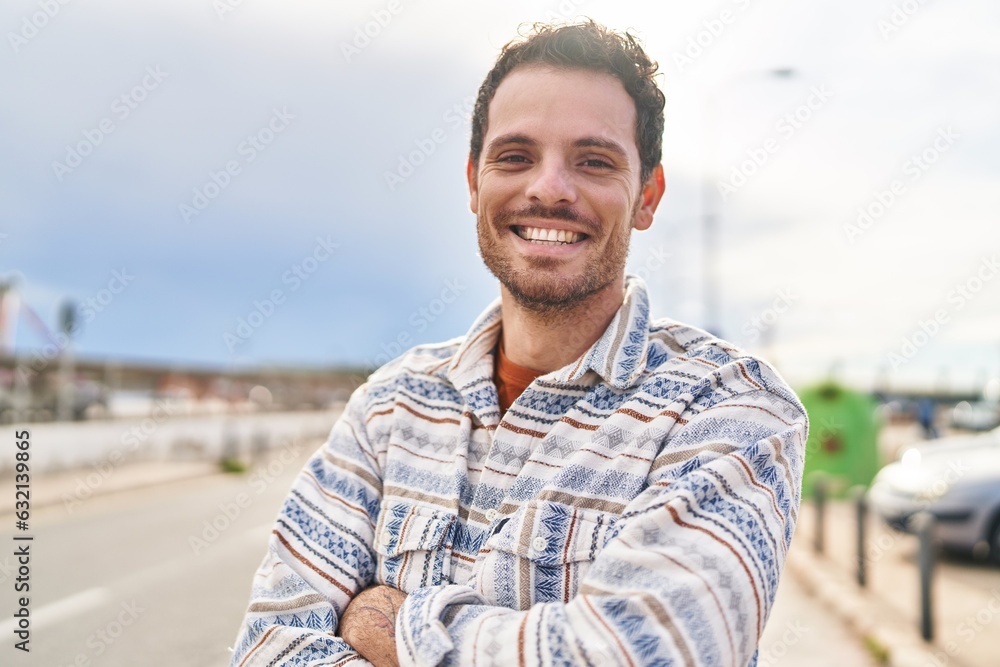 Young hispanic man smiling confident standing with arms crossed gesture at street Young hispanic man smiling confident standing with arms crossed gesture at street