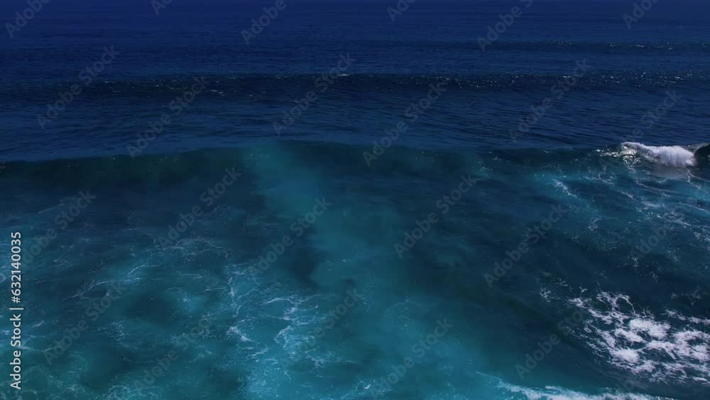 Slow motion steady drone shot of dark blue ocean waves rolling, crashing with thick foam and sunlight. Top view of beautiful water. Concept of relaxation and vacation Slow motion steady drone shot of dark blue ocean waves rolling, crashing with thick foam and sunlight. Top view of beautiful water. Concept of relaxation and vacation