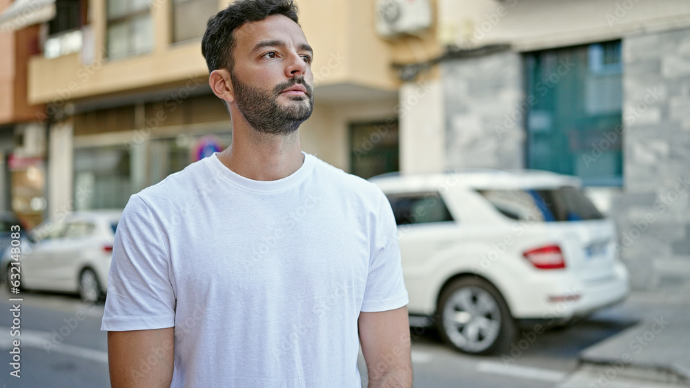 Young hispanic man looking to the side with serious expression at street Young hispanic man looking to the side with serious expression at street