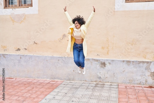 Young middle east woman excutive smiling confident jumping at street