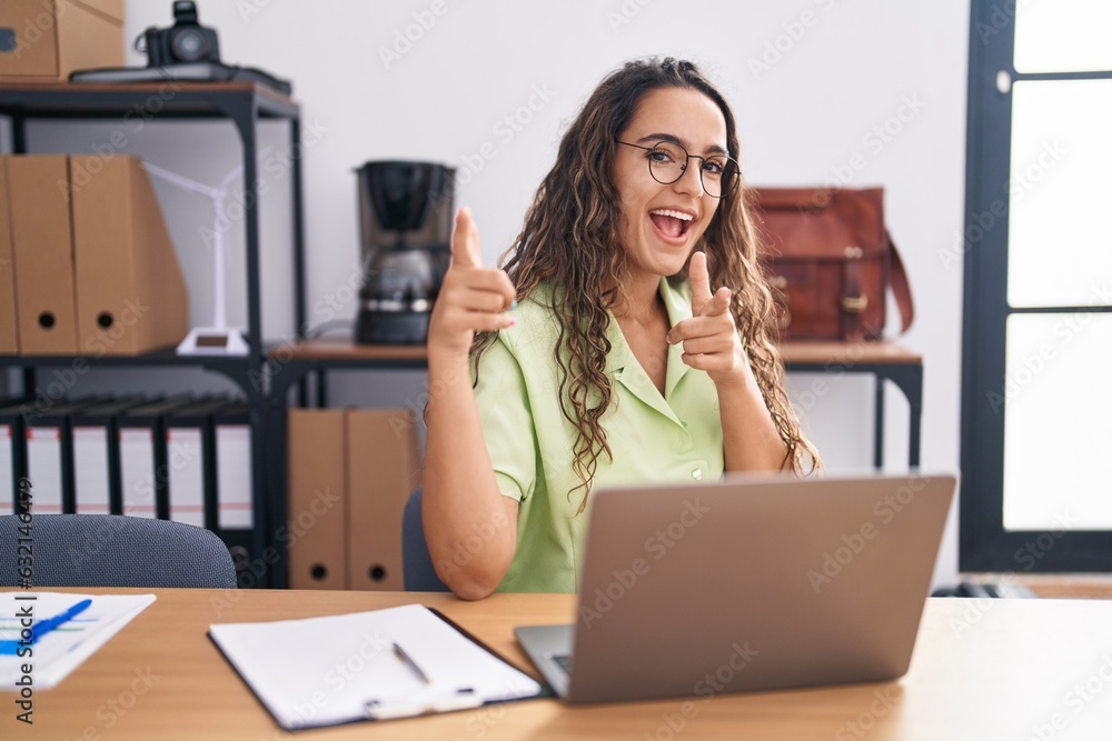 Young hispanic woman working at the office wearing glasses pointing fingers to camera with happy and funny face. good energy and vibes. Young hispanic woman working at the office wearing glasses pointing fingers to camera with happy and funny face. good energy and vibes.