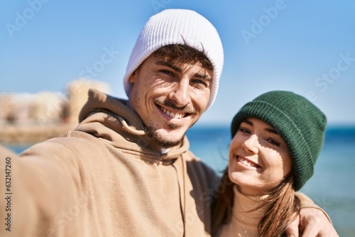 Mand and woman couple hugging each other make selfie by camera at seaside