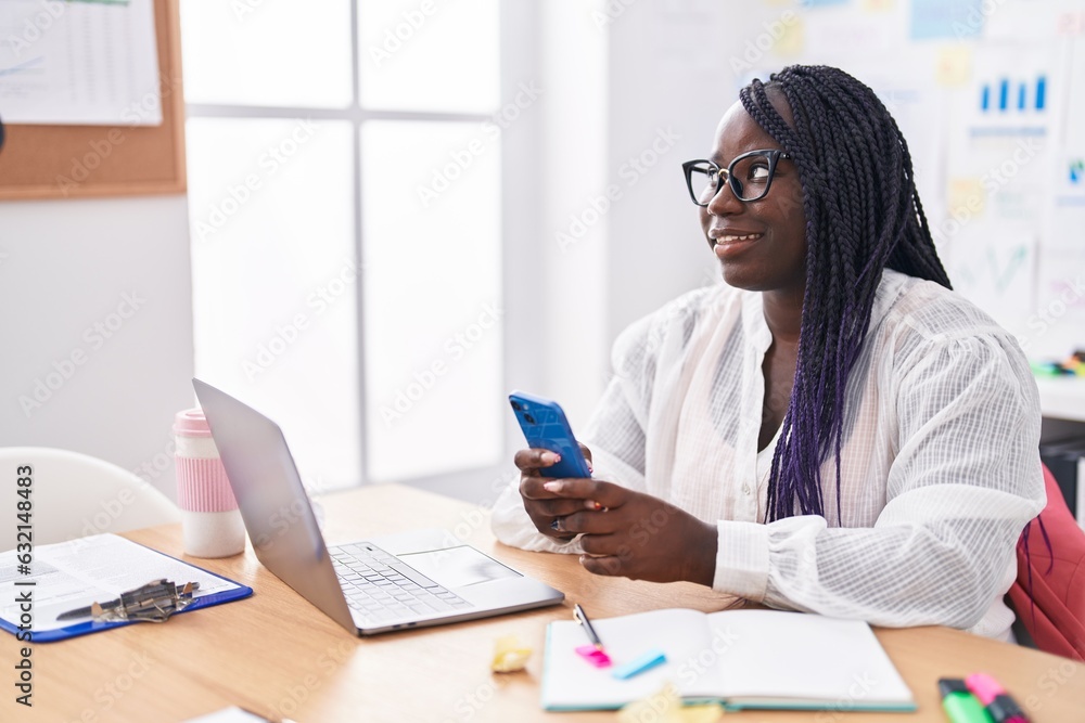 African american woman business worker using laptop and smartphone at office African american woman business worker using laptop and smartphone at office