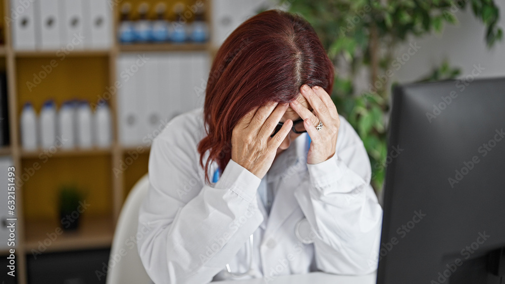 Middle age woman doctor stressed working at the clinic Middle age woman doctor stressed working at the clinic