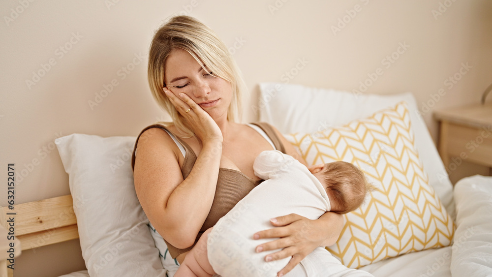 Mother and daughter sitting on bed breastfeeding baby tired yawning at bedroom Mother and daughter sitting on bed breastfeeding baby tired yawning at bedroom