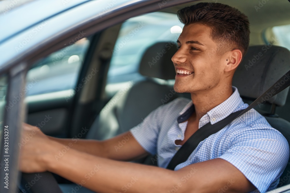 © Krakenimages.com - Young hispanic man smiling confident driving car at street © Krakenimages.com - Young hispanic man smiling confident driving car at street