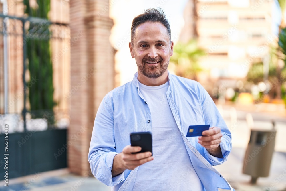 Young caucasian man using smartphone and credit card at street Young caucasian man using smartphone and credit card at street