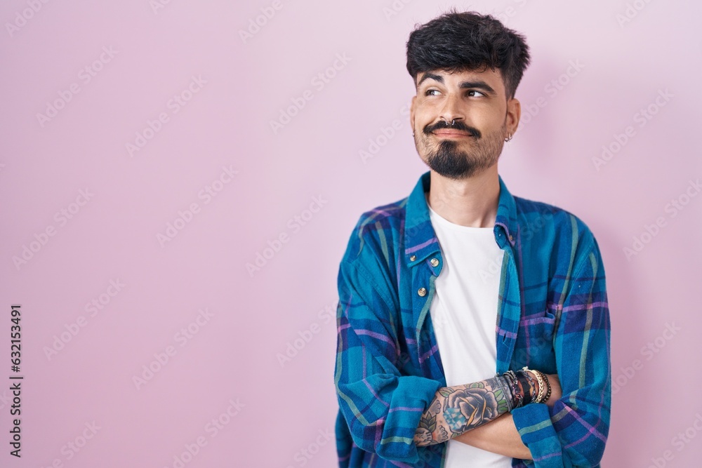 Young hispanic man with beard standing over pink background smiling looking to the side and staring away thinking. Young hispanic man with beard standing over pink background smiling looking to the side and staring away thinking.