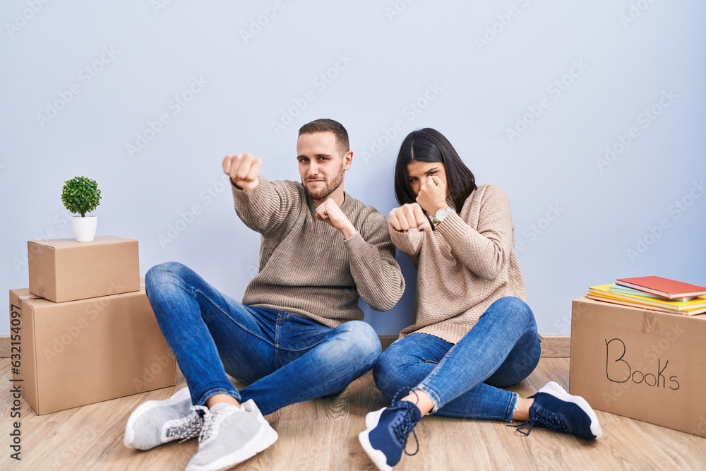 Young couple moving to a new home punching fist to fight, aggressive and angry attack, threat and violence Young couple moving to a new home punching fist to fight, aggressive and angry attack, threat and violence