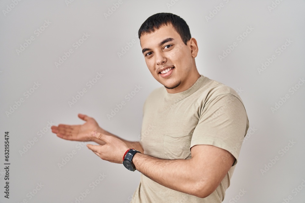 Young arab man wearing casual t shirt inviting to enter smiling natural with open hand Young arab man wearing casual t shirt inviting to enter smiling natural with open hand