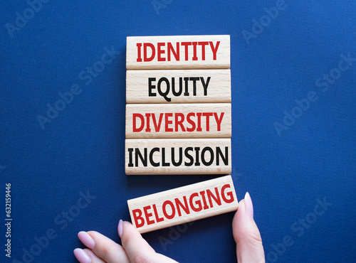 Identity Equity Diversity Inclusion Belonging symbol. Concept words Identity Equity Diversity Inclusion Belonging on wooden blocks. Businessman hand. Beautiful deep blue background. Business concept
