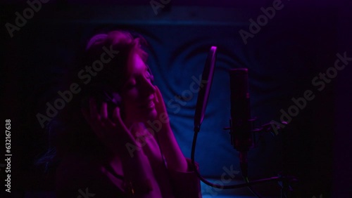 Portrait of talented singer girl singing new song in audio record studio photo