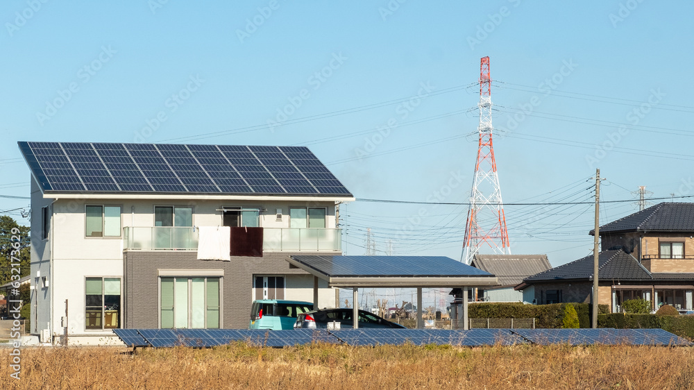 Kasukabe, Saitama, Japan. January 2, 2021. An eco-friendly house with solar panels on its roof and garage roof, as well as in a field out front of the house. Kasukabe, Saitama, Japan. January 2, 2021. An eco-friendly house with solar panels on its roof and garage roof, as well as in a field out front of the house.