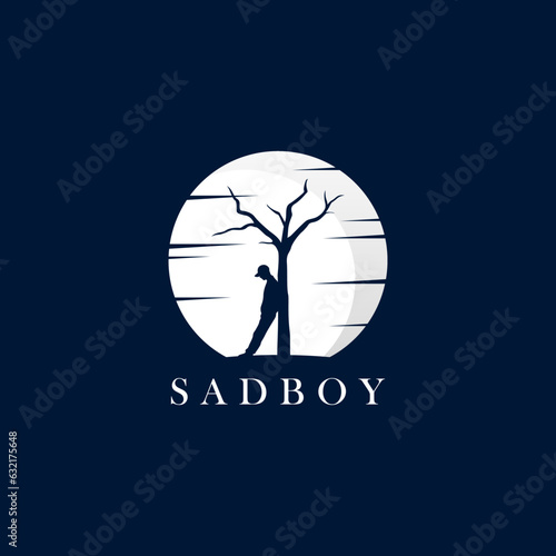 Boy leaning against dry tree with moonlight background for sad boy logo design photo