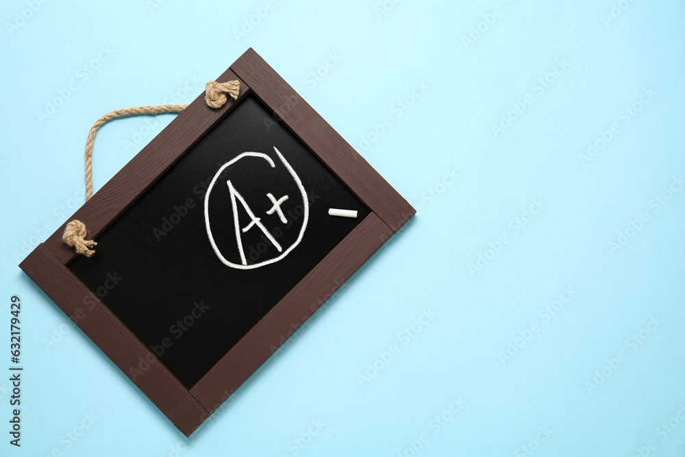 School grade. Small blackboard with chalked letter A and plus symbol on light blue background School grade. Small blackboard with chalked letter A and plus symbol on light blue background
