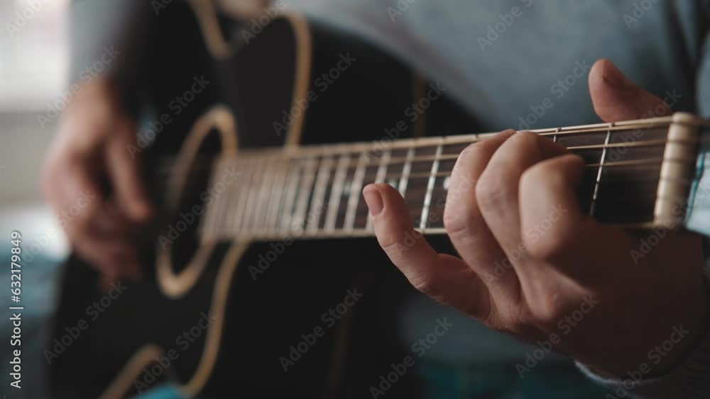 Playing the guitar. Strumming acoustic guitar. Musician plays music. Man fingers holding mediator. Man hand playing guitar neck in dark room. Unrecognizable person rehearsing, fretboard close-up. Playing the guitar. Strumming acoustic guitar. Musician plays music. Man fingers holding mediator. Man hand playing guitar neck in dark room. Unrecognizable person rehearsing, fretboard close-up.