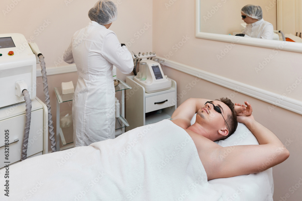 Obraz premium young man undergoes procedure of arm pit laser epilation